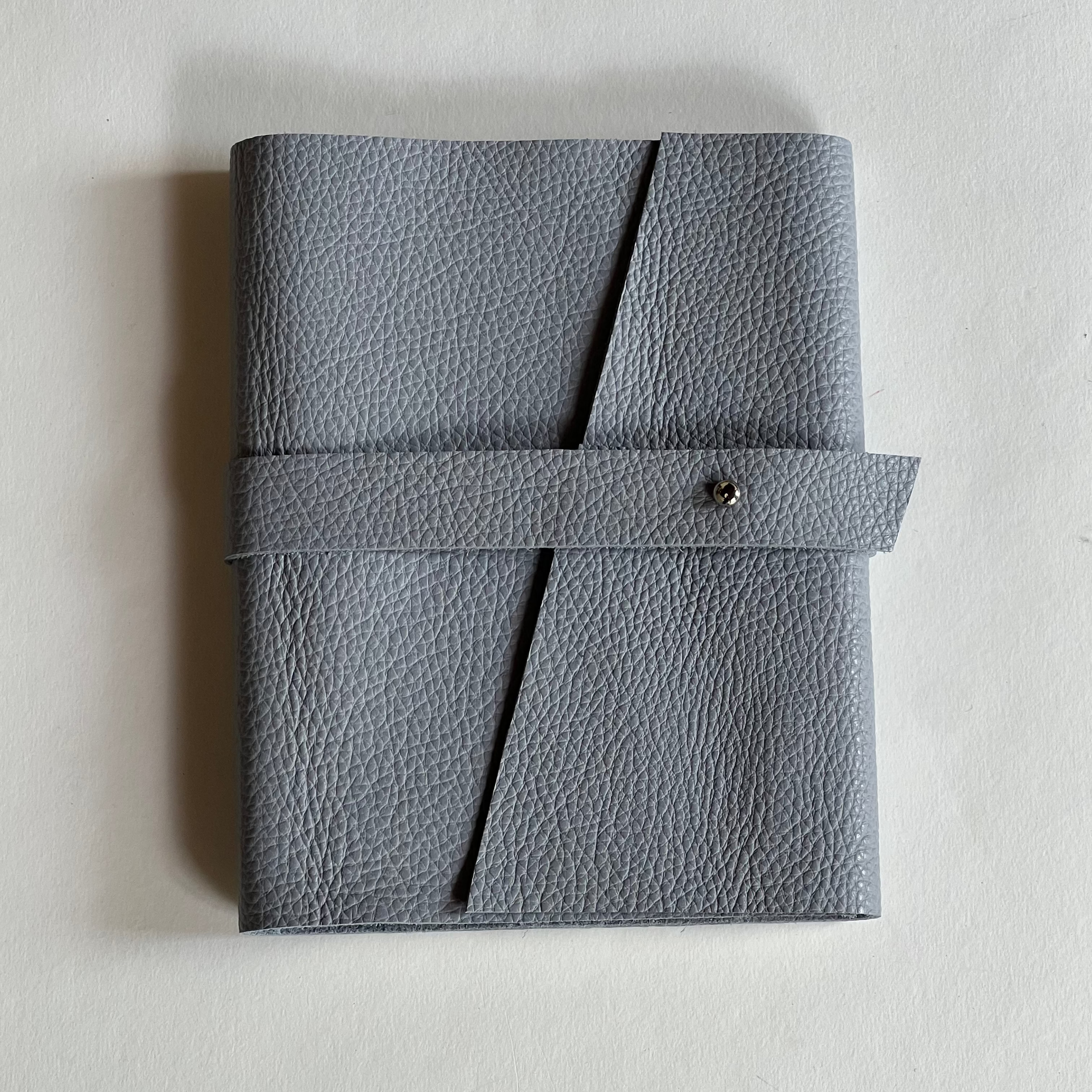 Greyish blue leather notebook with a strap